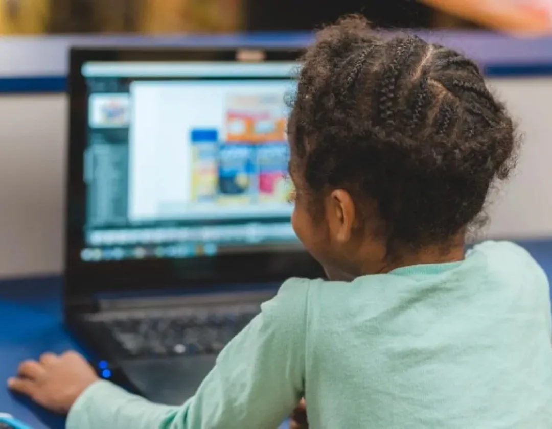 a girl looking at a laptop