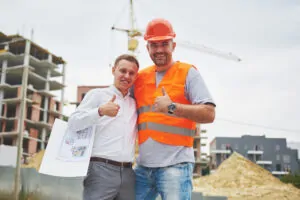 happy architects with blueprint at building site 2023 11 27 05 11 29 utc