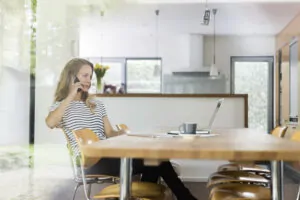 woman on cell phone sitting at table 2024 09 18 10 07 33 utc